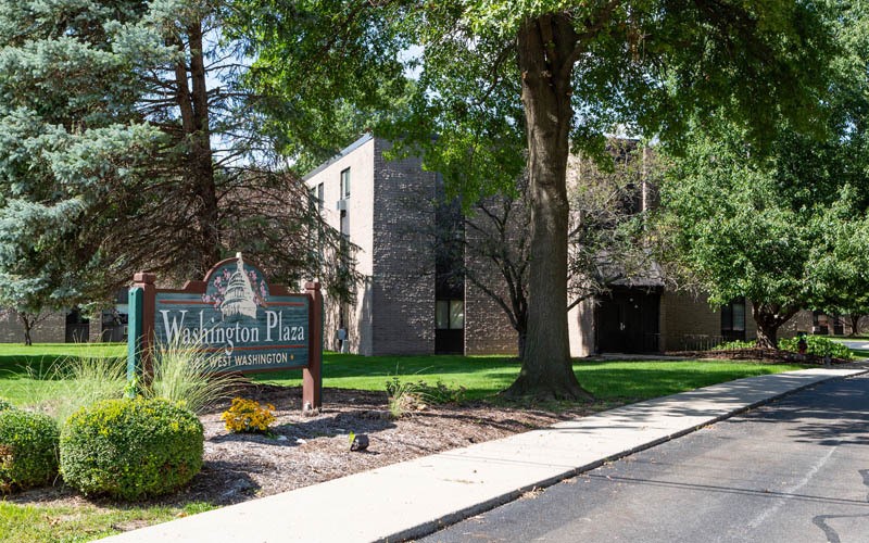 A sign for Washington Plaza stands in front of a building.
